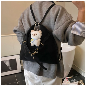 Detail of black versatile tote bag with gold hardware and white bear charm decoration
