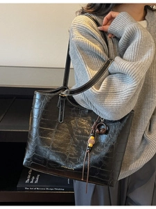 Classic black faux crocodile leather tote bag with gold logo and tassel charm