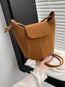 Retro caramel bucket bag in matte leather with contrast stitching and knot handle detail