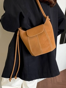 Retro tan leather bucket bag with contrast stitching and side tassel detail for women