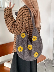 Sac hobo d'hiver en tricot gris avec motifs fleurs jaunes porté par un mannequin