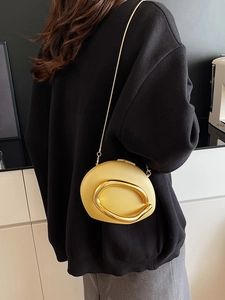 Bright yellow oval acrylic evening bag with bold gold U-shaped handle and chain strap