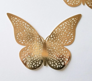 Macro shot of gold double-layer hollow butterfly wall sticker with laser-cut geometric patterns