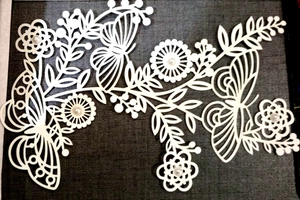 Laser cut floral pattern decoration with butterfly elements and pearl center accents