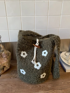 Handmade knitted bucket bag in olive green with floral patterns and drawstring closure