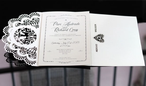 Detail of laser-cut lace wedding invitation with elegant cream-colored hollow cover and card