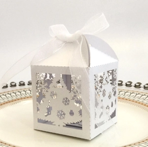 Detail of white laser-cut Christmas favor box with reindeer and snowflake patterns