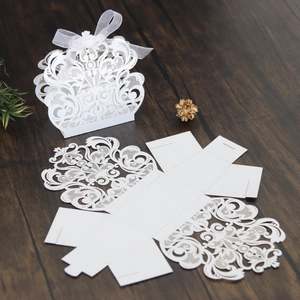 Detalle de caja de boda blanca cortada con láser con encaje de corona y cinta