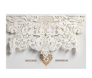 Elegant white laser-cut wedding invitation featuring hollow heart and vine patterns