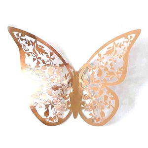 Macro detail of laser-cut rose gold butterfly wall sticker with hollow flower pattern