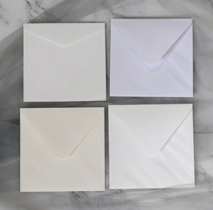 Detailed view of four elegant square wedding envelopes in various shades of premium white