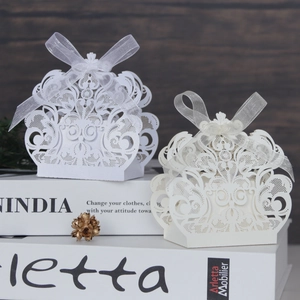 Detalle de cajas de caramelos de encaje cortadas con láser y lazos de cinta de organza