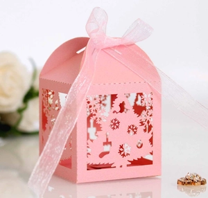 Detail of pink laser-cut gift box with festive hollow patterns and pink ribbon bow