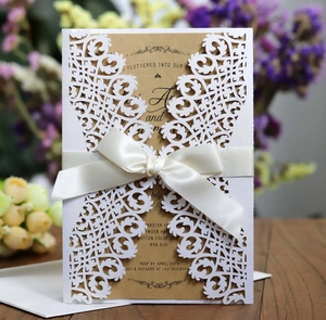 Détail d'invitation de mariage découpée au laser avec papier kraft et ruban de satin