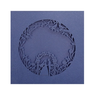 Macro detail of laser-cut wedding invitation featuring a romantic couple silhouette