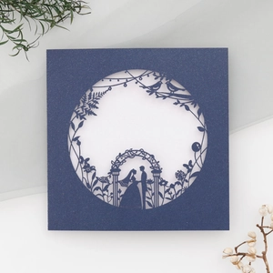 Detail of laser-cut navy blue wedding invitation card with pearlescent floral hollow pattern