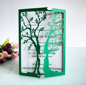 Detail of laser-cut green heart tree design invitation with elegant white paper insert
