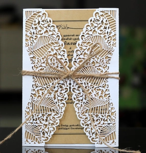 Close-up of laser-cut foliage pattern on white card with kraft paper and hemp twine