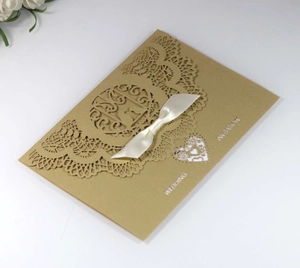 Detailed laser-cut hollow heart and lovebird design on brown kraft wedding invitation