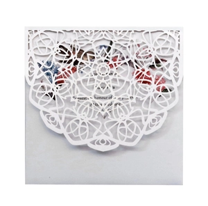 Elegant white laser-cut wedding invitation with floral insert and intricate hollow pattern