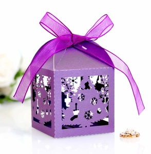 Close-up of laser-cut purple Christmas candy box with snowflake pattern and ribbon