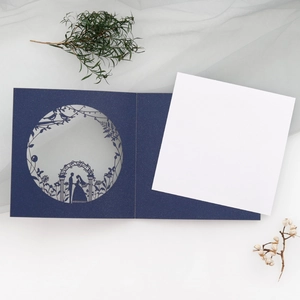 Macro view of laser-cut wedding invitation featuring elegant silhouette in dark blue