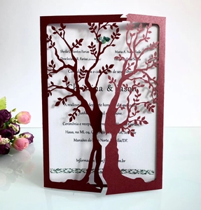 Macro shot of laser-cut burgundy invitation featuring a romantic heart tree design