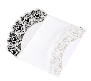 Detail of laser cut lace wedding invitation with intricate heart patterns and hollow design