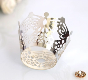 Intricate laser-cut gold lace cake wrappers with butterfly patterns for wedding decor