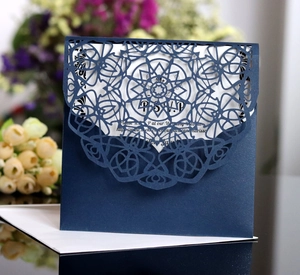 Detail of laser-cut navy blue wedding invitation with intricate mandala lace and RSVP card