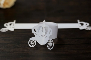 Macro shot of laser-cut white pumpkin carriage napkin ring on dark wood background