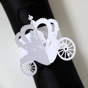 Laser cut paper napkin ring featuring an intricate white royal carriage on a dark napkin