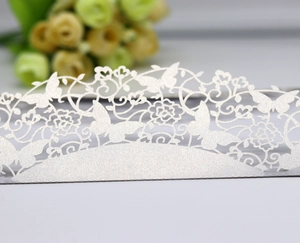 Détails macro de dentelle papillon découpée au laser sur carte d'invitation blanc nacré