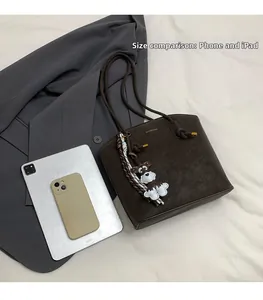 Brown textured bucket bag showing size comparison with tablet and a cute dog charm