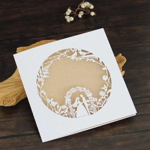 Detail of laser-cut white wedding invitation with romantic floral and couple motifs