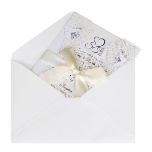 Detailed laser cut floral wedding invitation with cream ribbon bow and white envelope