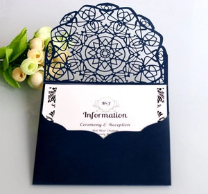 Detail of laser-cut navy blue wedding invitation set with elegant floral patterns