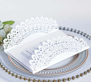Gros plan d'une carte d'invitation de mariage en dentelle découpée au laser sur plateau