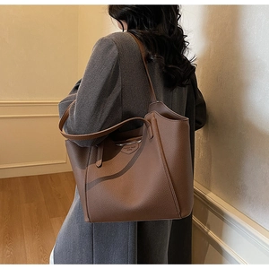 Detail view of coffee brown tote bag featuring pebbled leather and double strap design