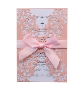 Detail of pink laser-cut wedding invitation featuring a silk ribbon bow and floral pattern
