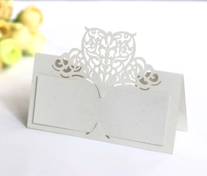Close-up of laser-cut cream heart floral place cards made of premium pearlescent paper