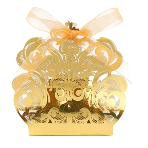 Detalle de caja dorada calada con láser para bodas con encaje floral y lazo de organza naranja