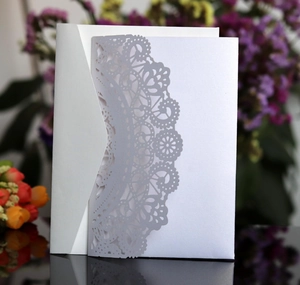Elegant white laser-cut wedding invitation with lace pattern and silver pearl paper