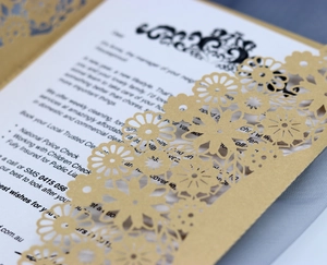 Détail des motifs floraux découpés au laser sur l'invitation en papier doré