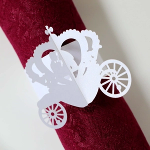 Close-up of laser-cut white pumpkin carriage paper napkin ring for wedding decor