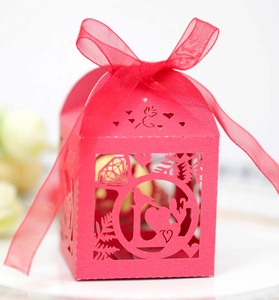 Close-up of red laser-cut candy box with LOVE text and elegant ribbon bow detail