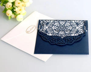 Detail of laser-cut navy blue wedding invitation cover with gold foil stamped envelope