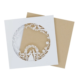 Detail of laser-cut wedding card with couple and floral motif and kraft envelope