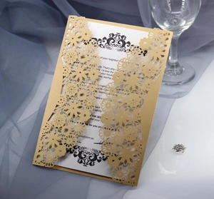 Vue macro d'un faire-part de mariage doré découpé au laser au motif floral élégant