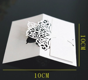 Detail of laser-cut white floral hollow pattern on pearl paper wedding place card